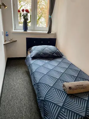 a small bedroom with a bed and a window at Topolove Rooms & Apartments in Kraków