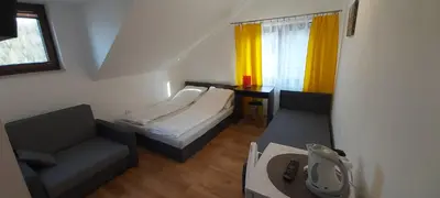 a small room with a bed and a couch and a table at PoziomKA in Jaszczurowa