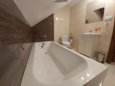 a large white tub in a bathroom with a toilet at PoziomKA in Jaszczurowa