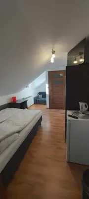 a bedroom with a large bed and a wooden floor at PoziomKA in Jaszczurowa