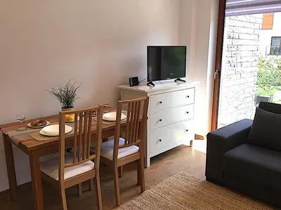 a living room with a dining room table with a tv at Apartment Novum Rakowicka Street in Kraków
