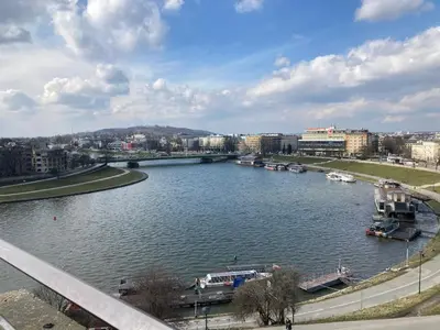 a view of a river with boats in a city at Apartment Novum Rakowicka Street in Kraków