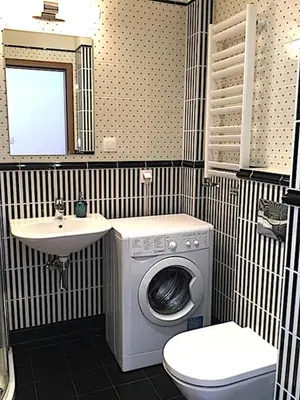 a bathroom with a washing machine and a sink at Apartment Novum Rakowicka Street in Kraków