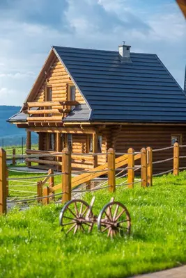 a log cabin with a fence and a house at Domki Zagroda Domek z bala z basenem & sauna & balia z hydromasażem in Słopnice