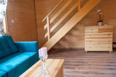 a living room with a blue couch and a table at Domki Zagroda Domek z bala z basenem & sauna & balia z hydromasażem in Słopnice