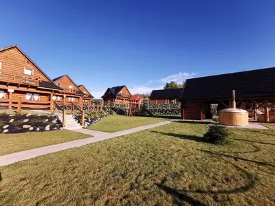 a yard of a house with a grassy yard at Domki Zagroda Domek z bala z basenem & sauna & balia z hydromasażem in Słopnice
