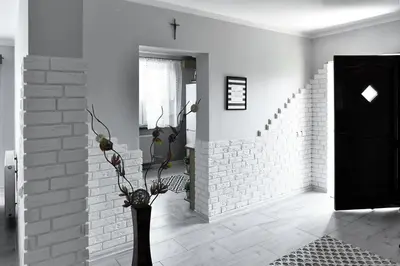 a white room with a black door and a vase with flowers at Apartament U Grazi in Spytkowice