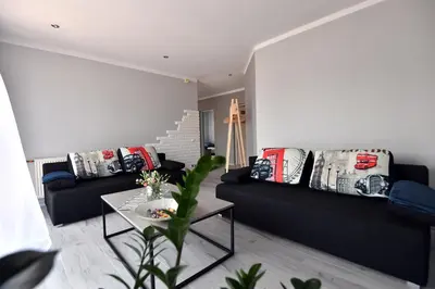 a living room with two black couches and a table at Apartament U Grazi in Spytkowice