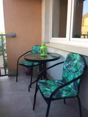 a table and two chairs with a green kettle on it at Cystersów 10 by Atrium Apartments in Kraków