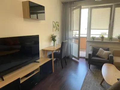 a living room with a large television and a table at Cystersów 10 by Atrium Apartments in Kraków