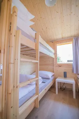 a bedroom with two bunk beds in a wooden cabin at Słoneczny Ogród domki letniskowe Zator in Zator