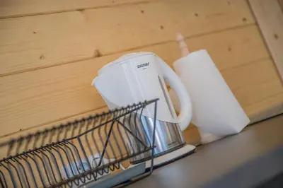 a coffee maker and a roll of toilet paper on a counter at Słoneczny Ogród domki letniskowe Zator in Zator