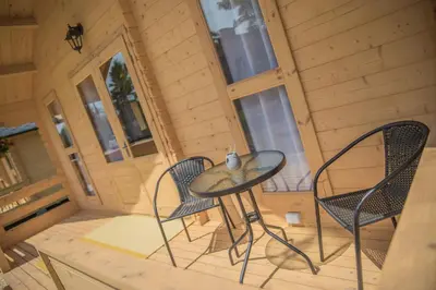 a small table and two chairs on the porch of a cabin at Słoneczny Ogród domki letniskowe Zator in Zator