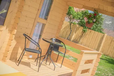 a small table and two chairs on a porch at Słoneczny Ogród domki letniskowe Zator in Zator