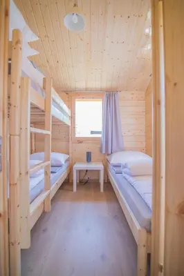 a room with two bunk beds and a table at Słoneczny Ogród domki letniskowe Zator in Zator