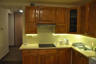 a kitchen with wooden cabinets and a stove top oven at Wenecja 4A by Homeprime in Kraków