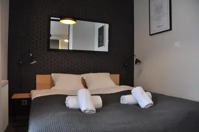 a bedroom with a bed with white pillows and a mirror at Rakowicka 22J (B) by Homeprime in Kraków