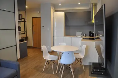 a kitchen and a table and chairs in a room at Rakowicka 22J (B) by Homeprime in Kraków