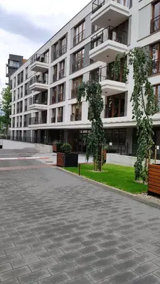 a large white building with a tree in front of it at Rakowicka 22J (B) by Homeprime in Kraków