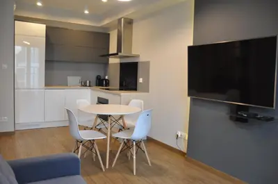 a kitchen with a table and chairs and a tv at Rakowicka 22J (B) by Homeprime in Kraków