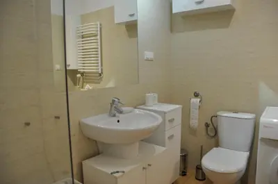 a bathroom with a sink and a toilet and a mirror at aleja Krasińskiego 30 by Homeprime in Kraków