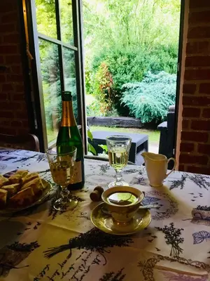 a table with a bottle of wine and a plate of food at Dom Pod Orzechem in Łapczyca