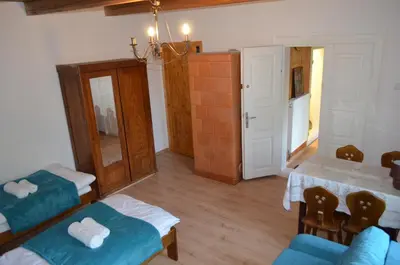 a living room with two beds and a table at Kolorowy Domek in Kasina Wielka