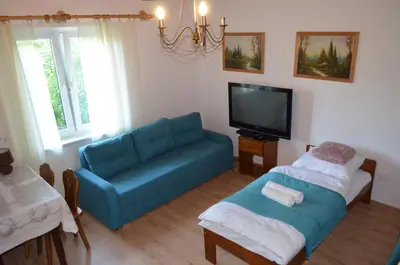 a living room with a blue couch and a tv at Kolorowy Domek in Kasina Wielka