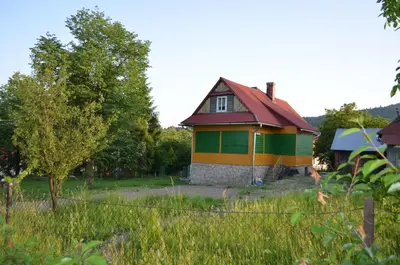 a small yellow and green house with a red roof at Kolorowy Domek in Kasina Wielka