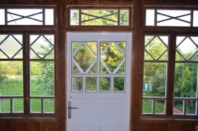 a room with a white door and four windows at Kolorowy Domek in Kasina Wielka