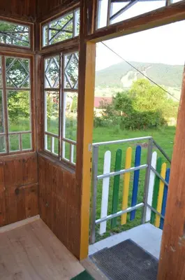 a room with a door and a fence with surfboards at Kolorowy Domek in Kasina Wielka
