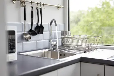 a kitchen sink with a dish drying rack and a window at Boleslav Home in Sucha Beskidzka