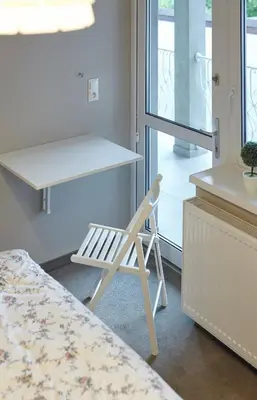 a white chair sitting in a room with a desk at Boleslav Home in Sucha Beskidzka
