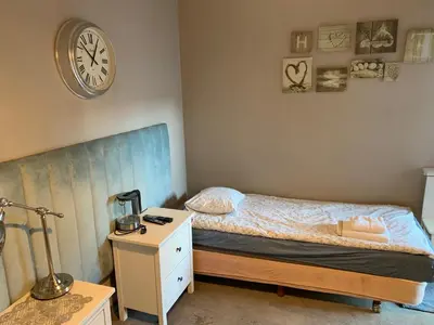 a bedroom with a bed and a clock on the wall at Boleslav Home in Sucha Beskidzka