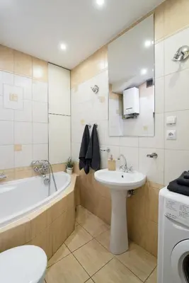 a bathroom with a tub and a sink and a washing machine at THE HEART OF NOWA HUTA - free garage in Kraków