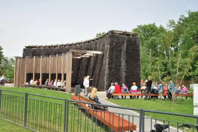a group of people sitting on benches in front of a building at THE HEART OF NOWA HUTA - free garage in Kraków