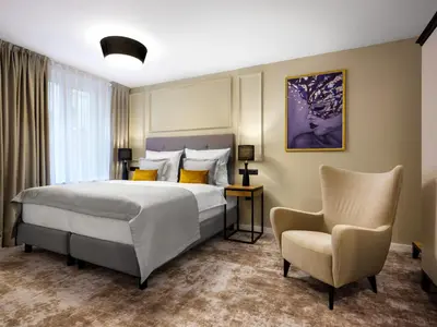 a bedroom with a bed and a chair at Hotel Wawel Queen in Kraków