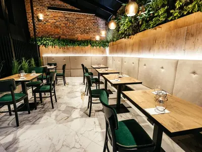 a restaurant with wooden tables and green chairs at Hotel Wawel Queen in Kraków
