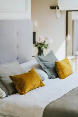 a row of pillows on a bed with yellow pillows at Hotel Wawel Queen in Kraków