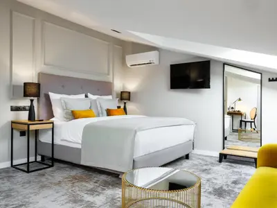 a bedroom with a white bed and a tv at Hotel Wawel Queen in Kraków
