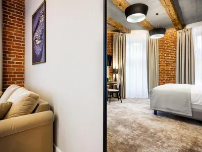 a room with a bed and a couch and a bedroom at Hotel Wawel Queen in Kraków