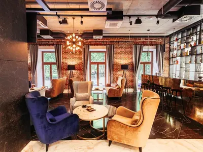 a lobby with chairs and tables and a bar at Hotel Wawel Queen in Kraków
