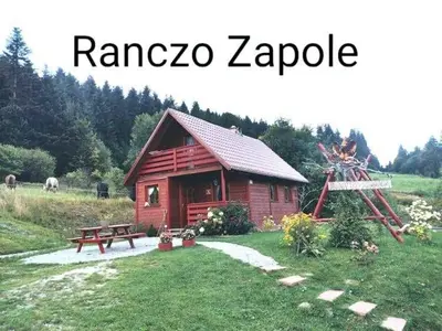 a small log cabin with a picnic table and a bench at Ranczo Zapole in Zasadne