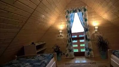 an attic room with a window and a bed at Ranczo Zapole in Zasadne