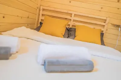 a bedroom with a bed with yellow pillows at FamilyCamp in Zator