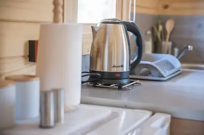 a coffee pot sitting on a counter next to a roll of paper towels at FamilyCamp in Zator