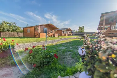 a garden with flowers and a wooden house at FamilyCamp in Zator