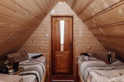a attic room with two beds and a door at Domek na uboczu in Klikuszowa