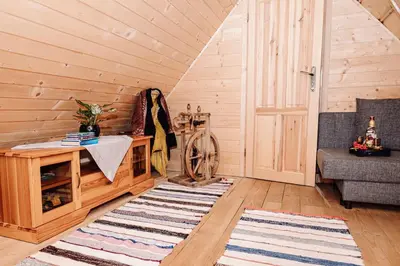 a living room with a wooden paneled wall at Domek na uboczu in Klikuszowa