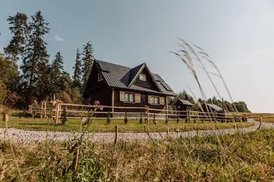 a wooden house in the middle of a field at Domek na uboczu in Klikuszowa